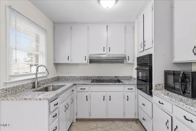 a kitchen with stainless steel appliances granite countertop a sink stove and cabinets