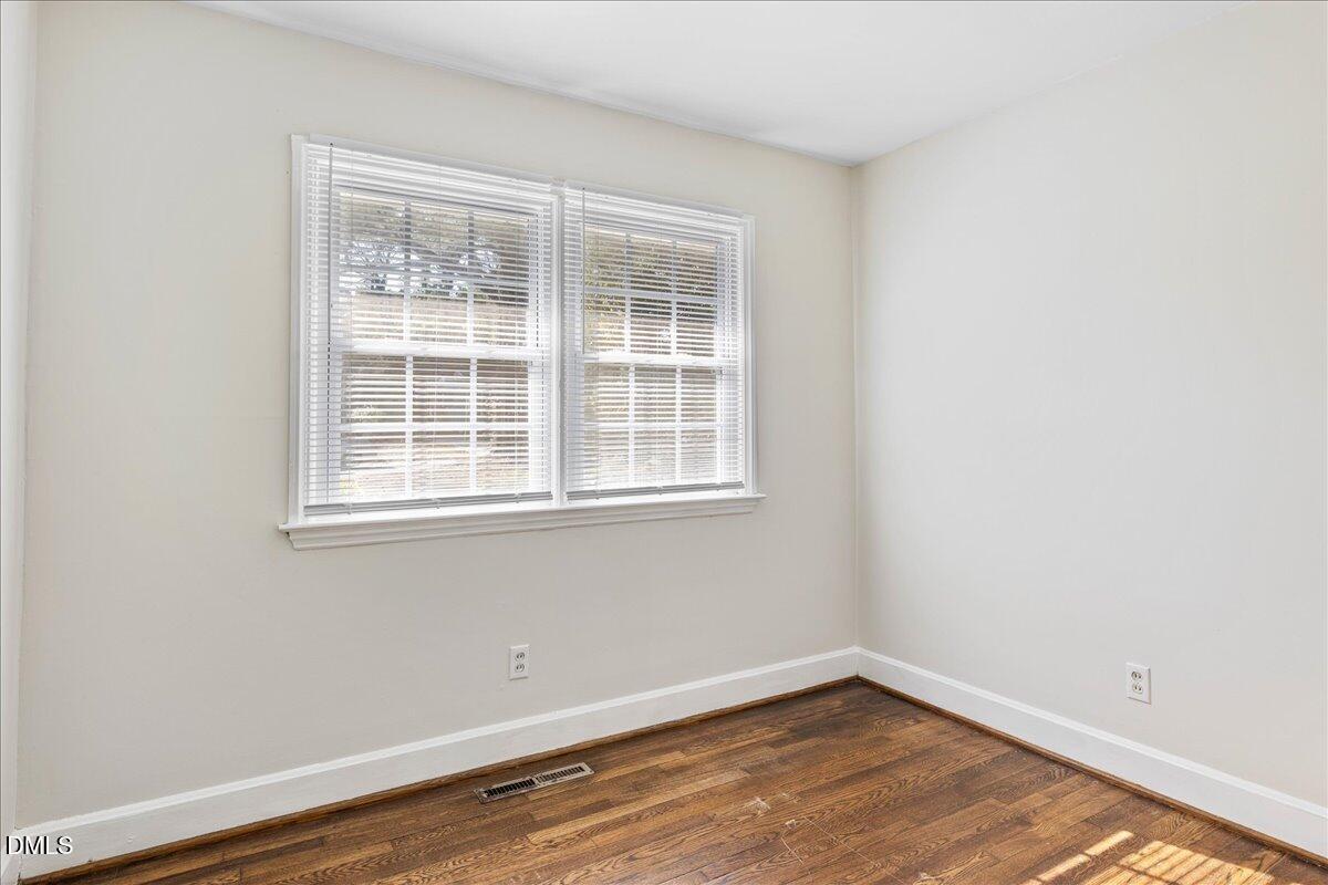513 Calloway Drive Raleigh, NC 27610 - Photo 12 of 19 an empty room with wooden floor and windows