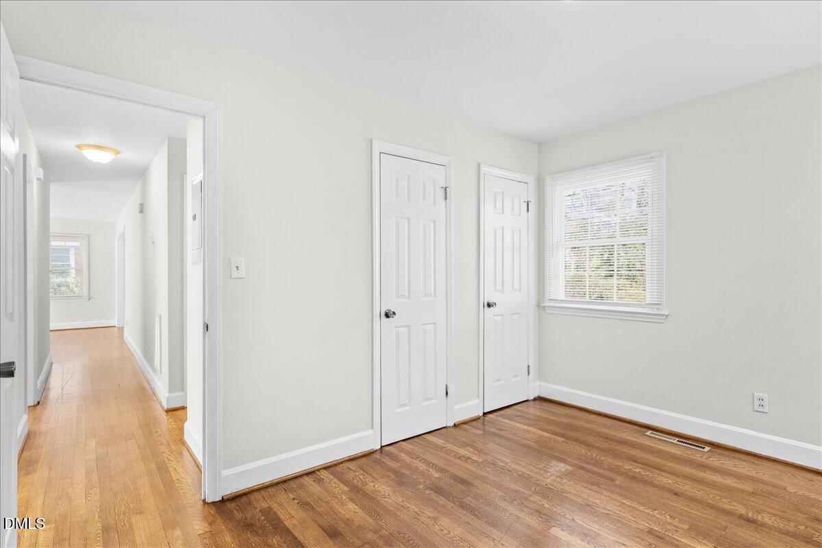 513 Calloway Drive Raleigh, NC 27610 - Photo 17 of 19 a view of an empty room with wooden floor and a bathroom
