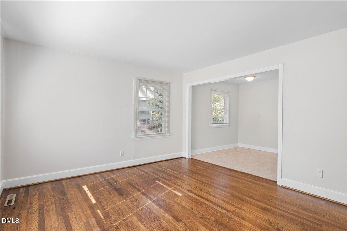 513 Calloway Drive Raleigh, NC 27610 - Photo 3 of 19 an empty room with wooden floor and windows