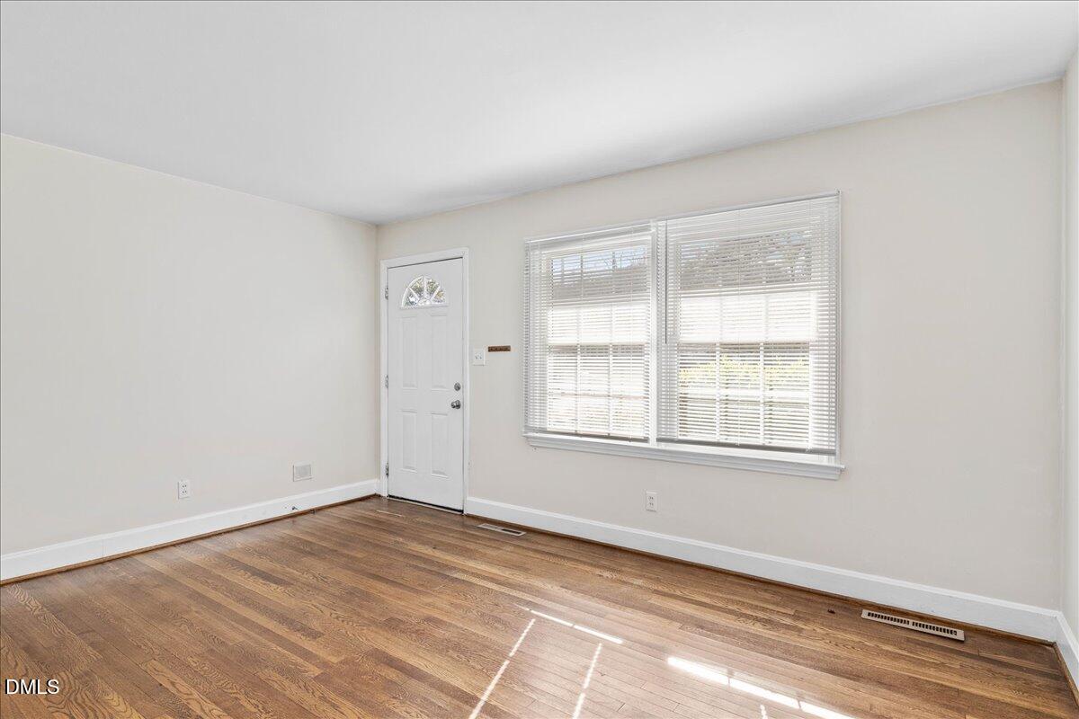 513 Calloway Drive Raleigh, NC 27610 - Photo 4 of 19 an empty room with wooden floor and windows