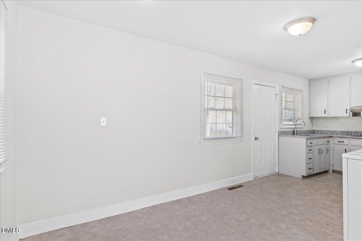 513 Calloway Drive Raleigh, NC 27610 - Photo 6 of 19 an empty room with a kitchen