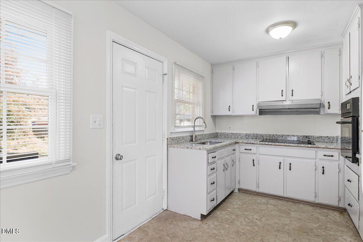 513 Calloway Drive Raleigh, NC 27610 - Photo 8 of 19 a kitchen with granite countertop white cabinets and sink