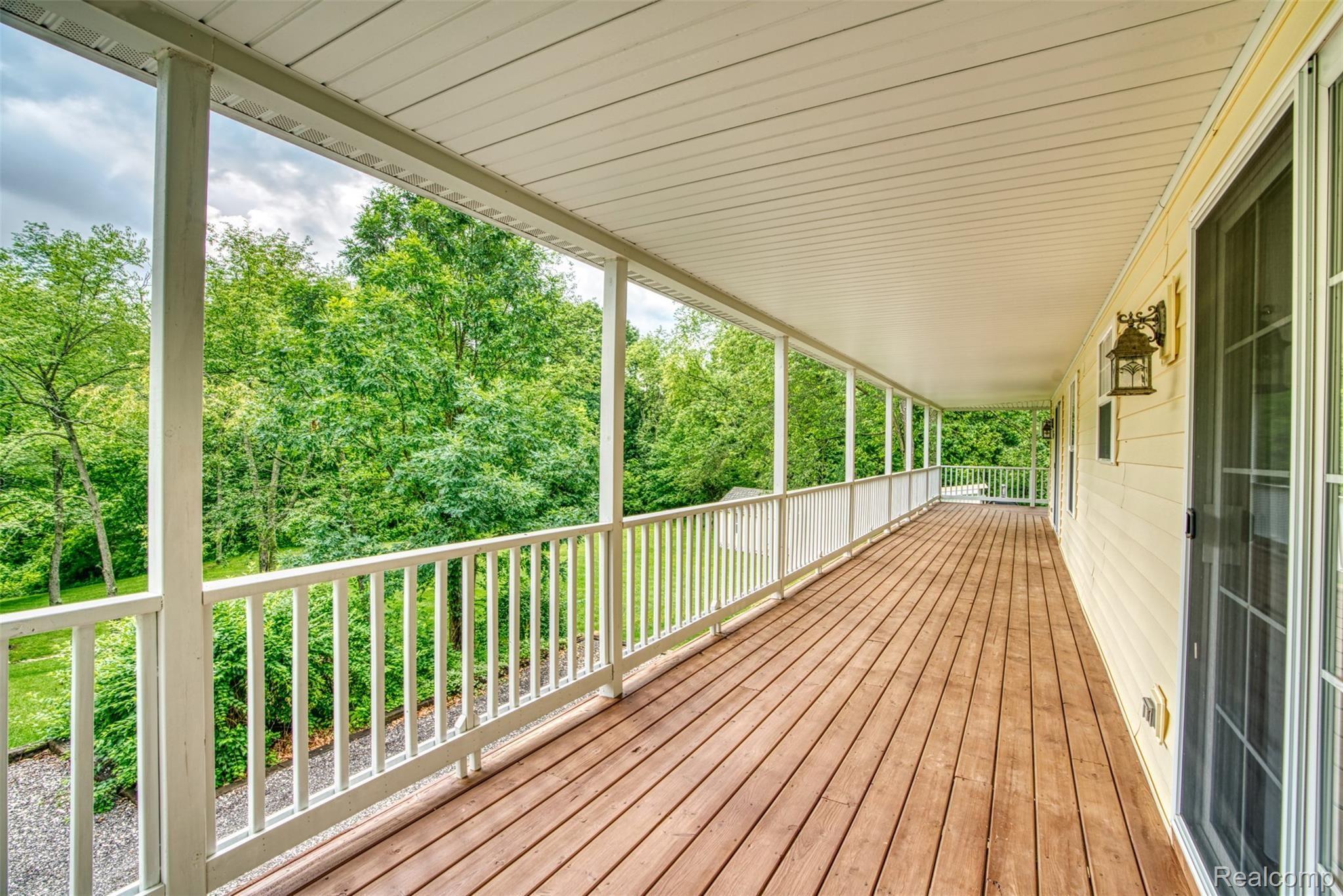 7016 West Lange Road Fowlerville, MI 48836 - Photo 20 of 61 PORCH RUNS ALONG THE BACKSIDE OF THE HOUSE. SLIDER TO THE RIGHT ACESSES THE MASTER BEDROOM!