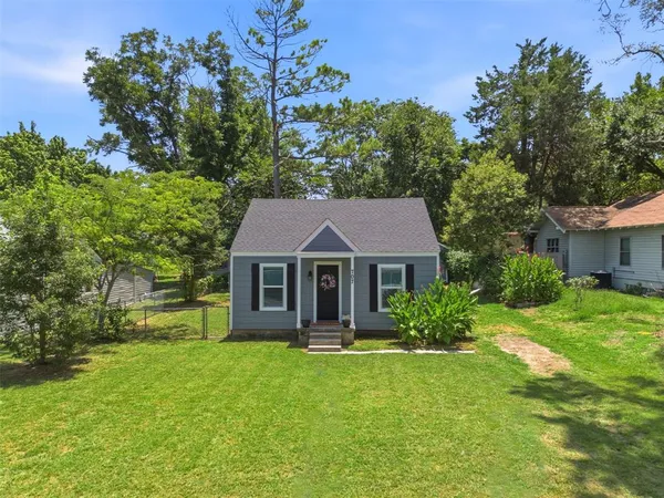 a front view of a house with a garden and yard