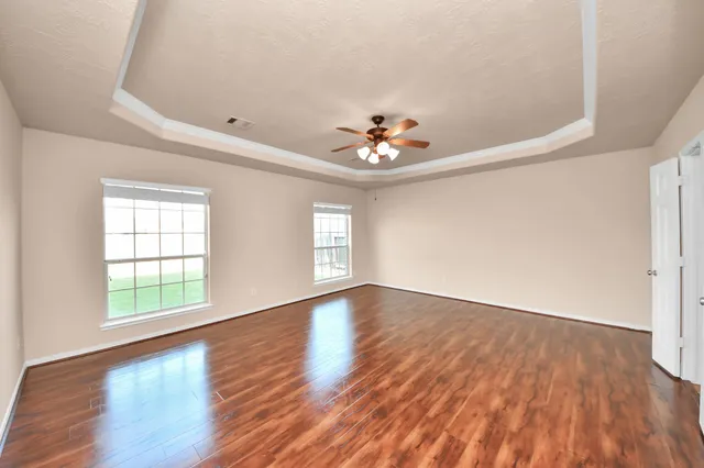 an empty room with wooden floor and window