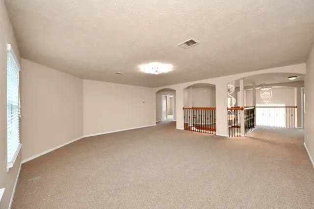 a view of empty room with kitchen and window