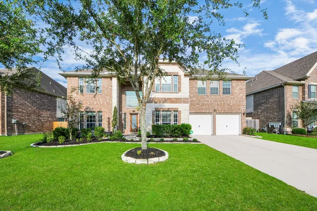 a view of a house with a big yard and large trees
