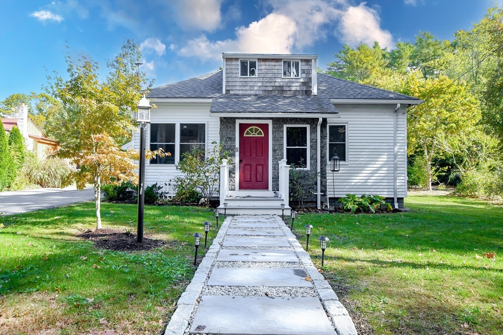 a front view of a house with a yard and garden