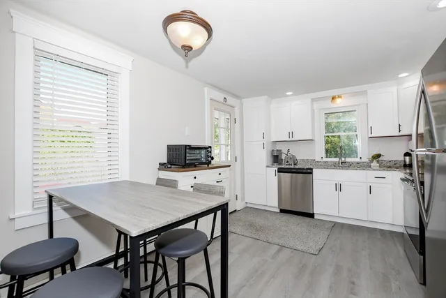 a kitchen with a table chairs sink and cabinets