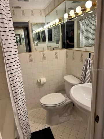 a bathroom with a sink a toilet a mirror and vanity