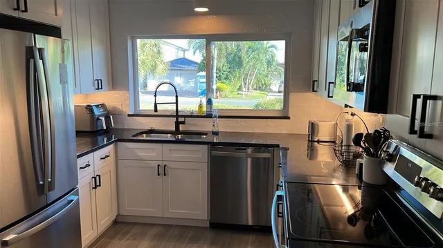 a kitchen with a sink appliances and cabinets