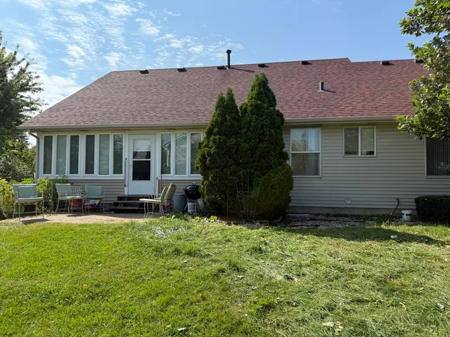 a view of a house with a yard and sitting area