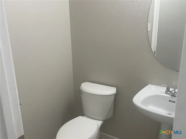a white toilet sitting next to a white sink