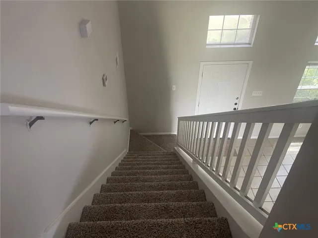 a view of staircase with white walls and a window