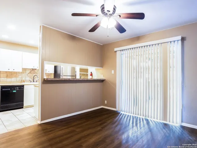 a view of a livingroom with a ceiling fan and wooden floor