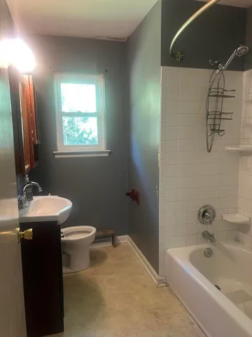 a bathroom with a sink a toilet and bathtub