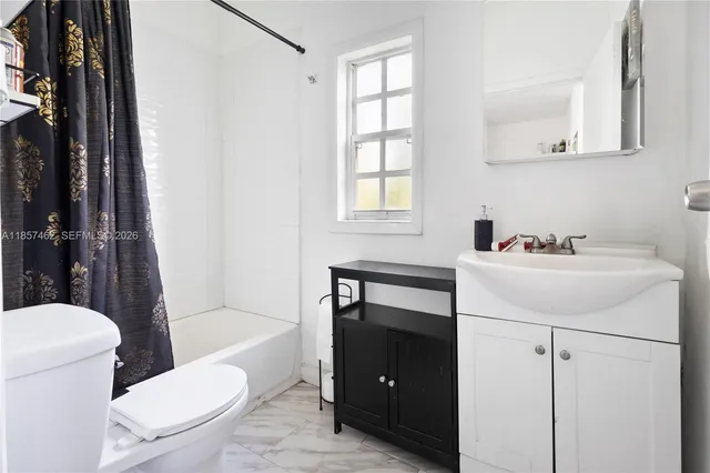 a bathroom with a sink toilet vanity and tub