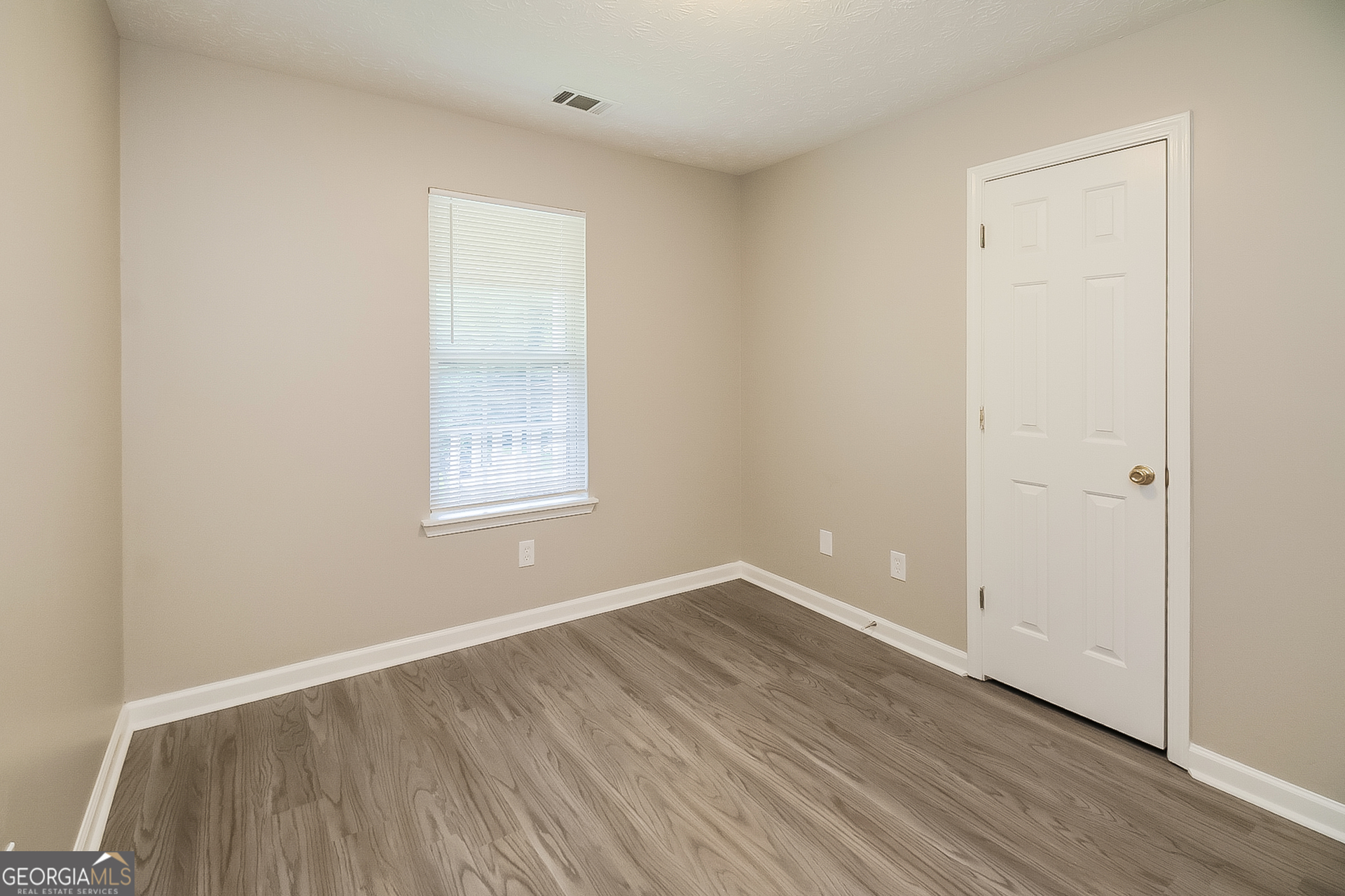 8303 Lakeview Drive Southwest Covington, GA 30014 - Photo 12 of 16 an empty room with wooden floor and windows
