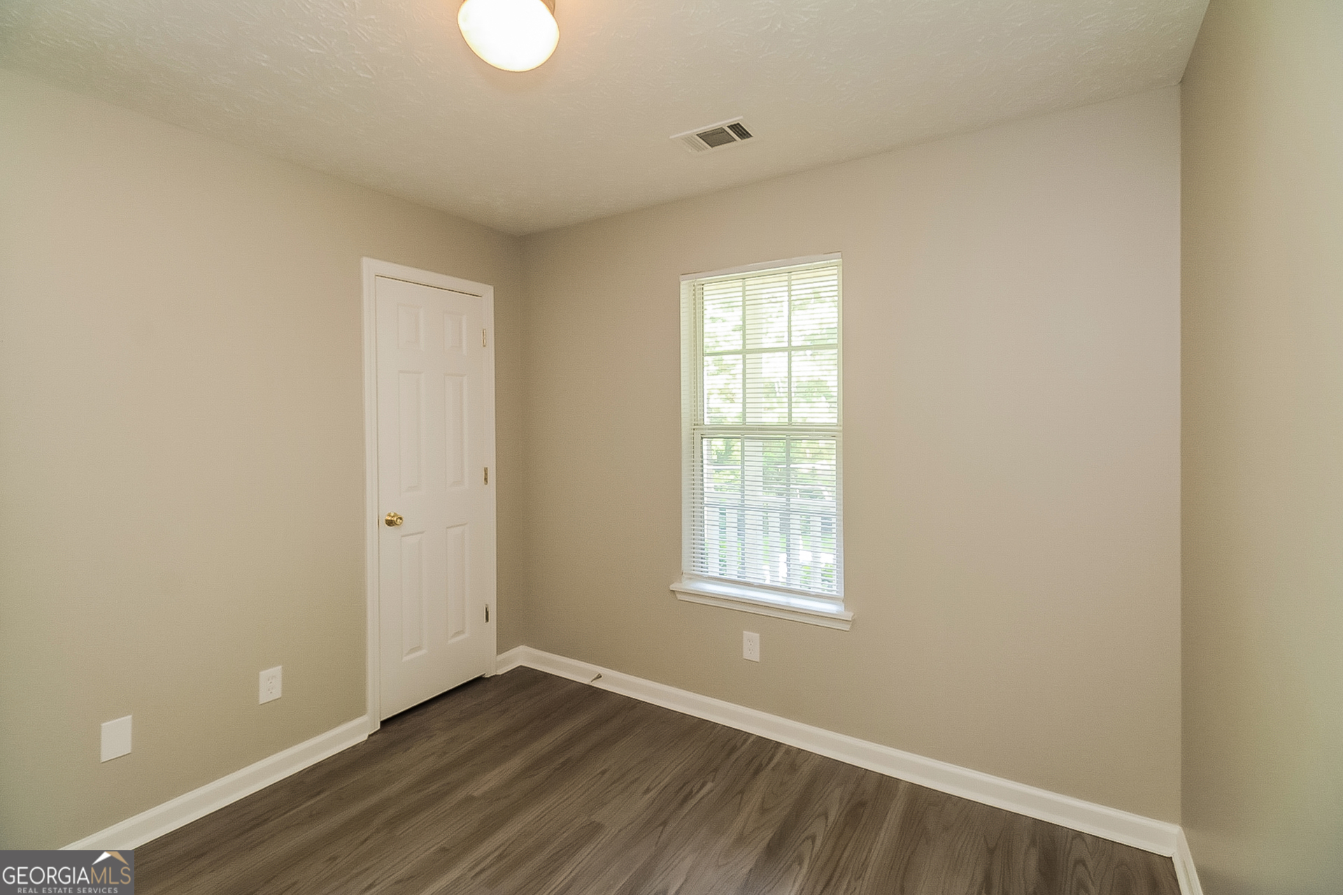 8303 Lakeview Drive Southwest Covington, GA 30014 - Photo 13 of 16 an empty room with wooden floor and windows