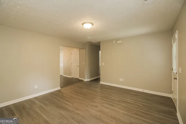 a view of an empty room with wooden floor
