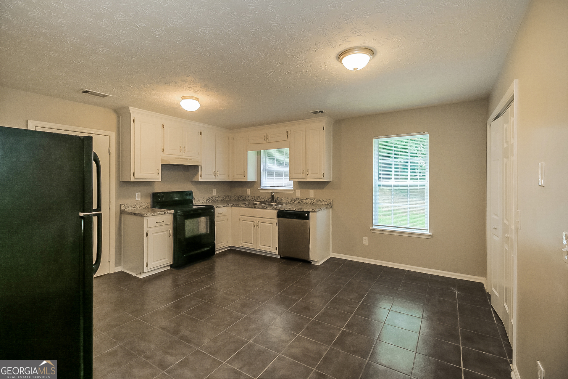 8303 Lakeview Drive Southwest Covington, GA 30014 - Photo 6 of 16 a kitchen with a refrigerator sink and cabinets