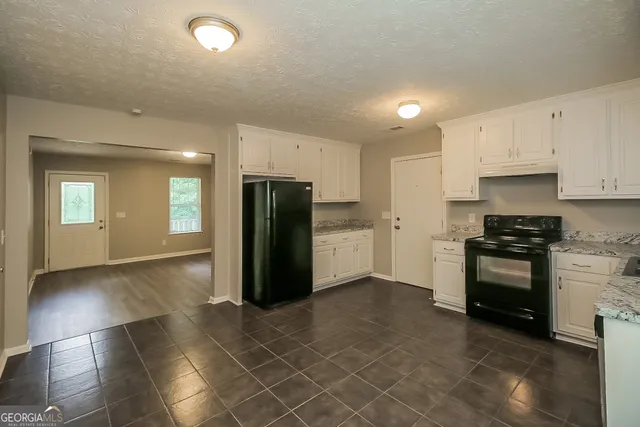 a kitchen with stainless steel appliances granite countertop a refrigerator a stove top oven and a sink
