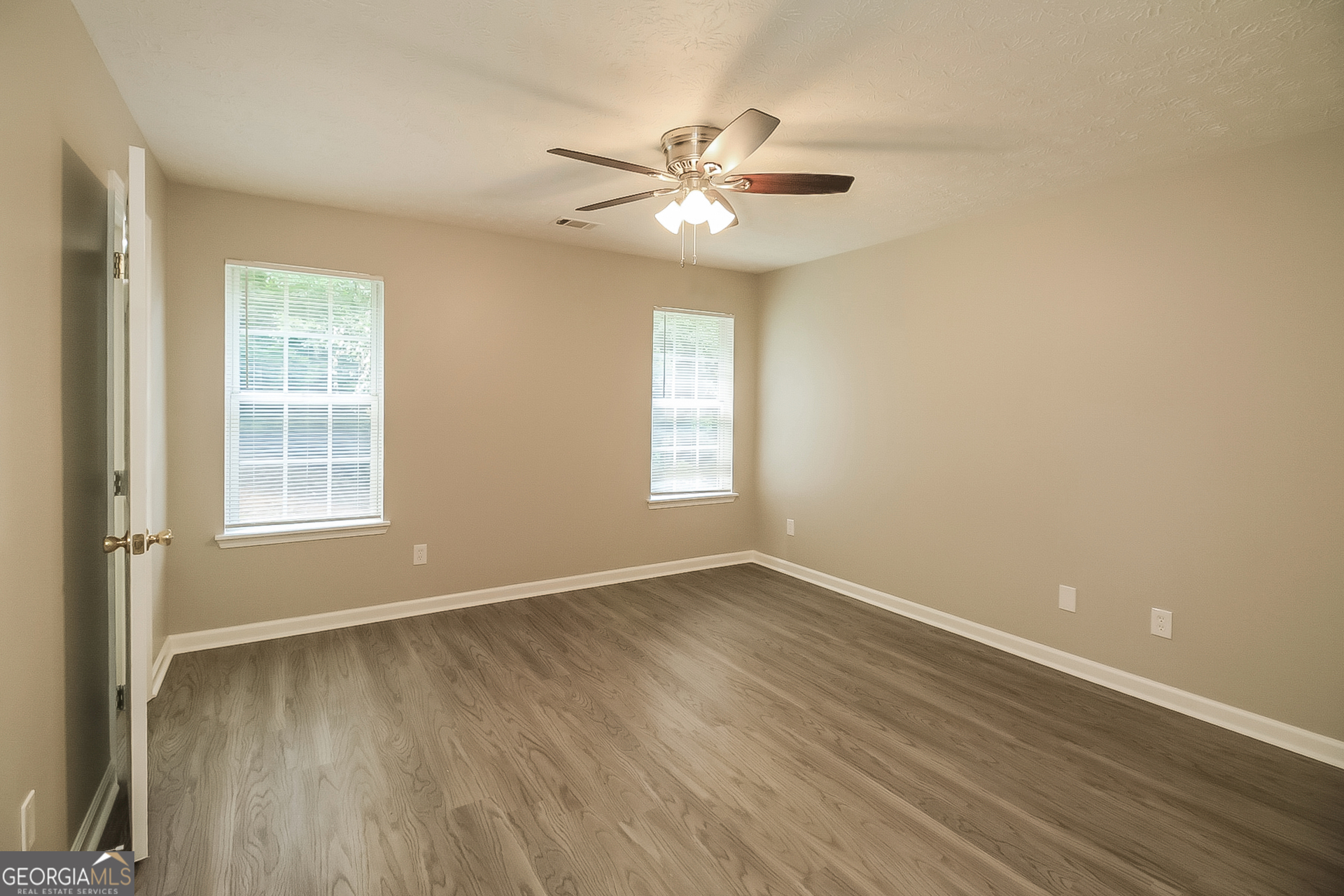 8303 Lakeview Drive Southwest Covington, GA 30014 - Photo 9 of 16 a view of an empty room with wooden floor and a window