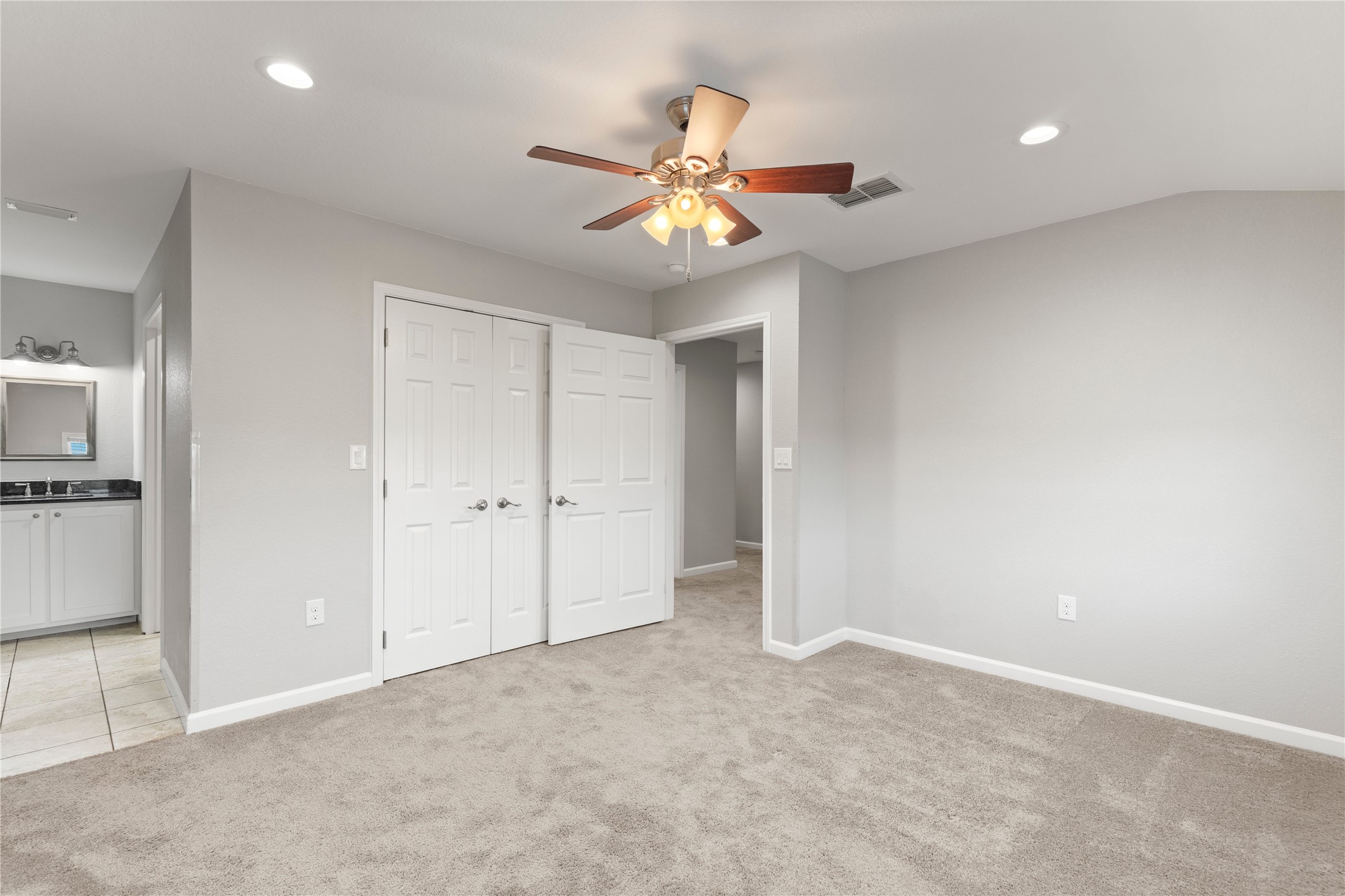 1293 Pioneer Road Seguin, TX 78155 - Photo 30 of 40 A spacious bedroom with plush carpeting, offering convenient access to a private vanity area.