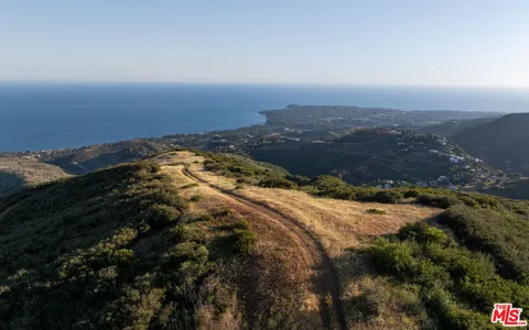 an aerial view of a house with a yard and mountain view in back