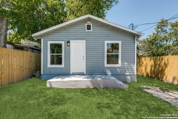 a backyard of a house with table and chairs