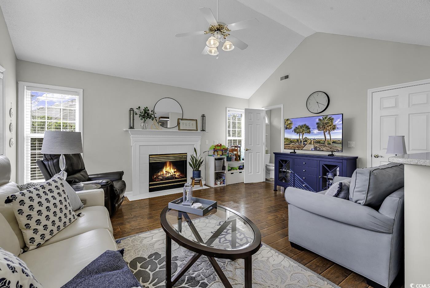 86 Black River Road Myrtle Beach, SC 29588 - Photo 13 of 40 Living room featuring hardwood / wood-style flooring, ceiling fan, a fireplace, and high vaulted ceiling