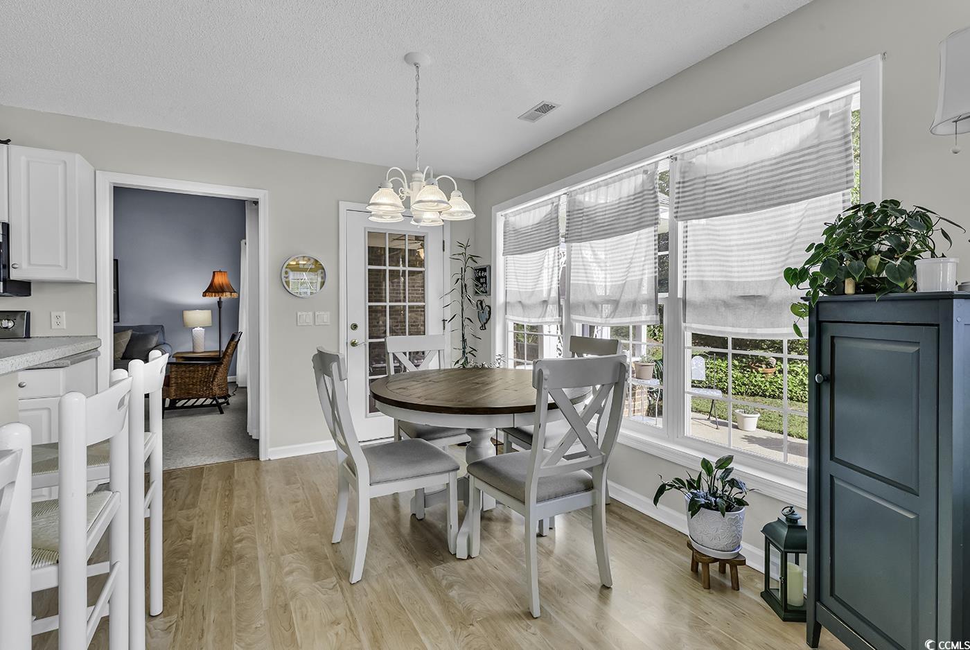 86 Black River Road Myrtle Beach, SC 29588 - Photo 16 of 40 Dining area featuring a chandelier, light wood finished floors, baseboards.