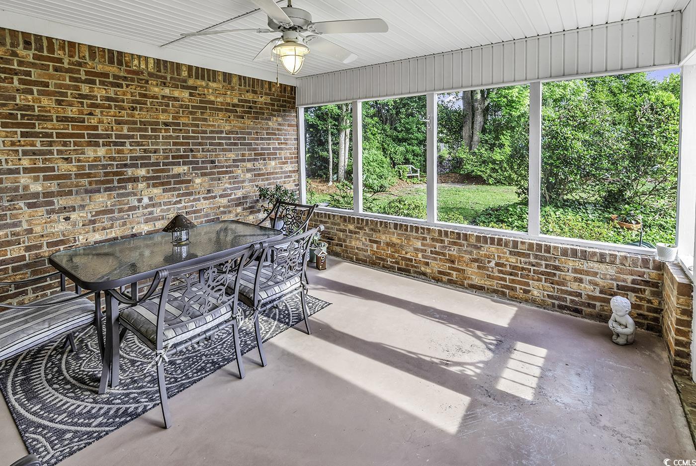 86 Black River Road Myrtle Beach, SC 29588 - Photo 28 of 40 Screened Porch featuring a ceiling fan and outdoor dining area