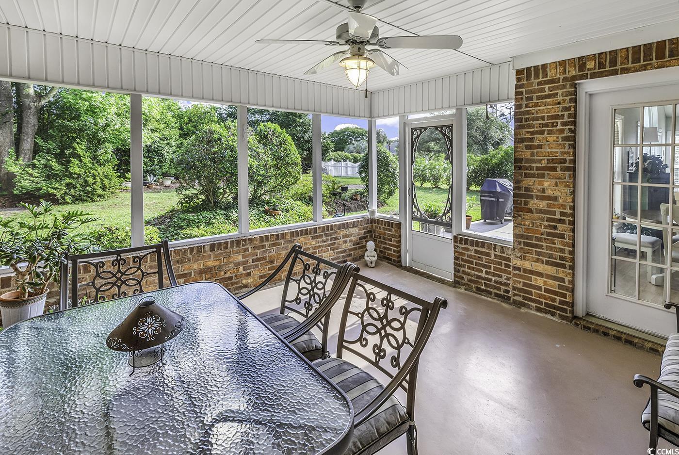 86 Black River Road Myrtle Beach, SC 29588 - Photo 29 of 40 Screened Porch with a ceiling fan and outdoor dining area