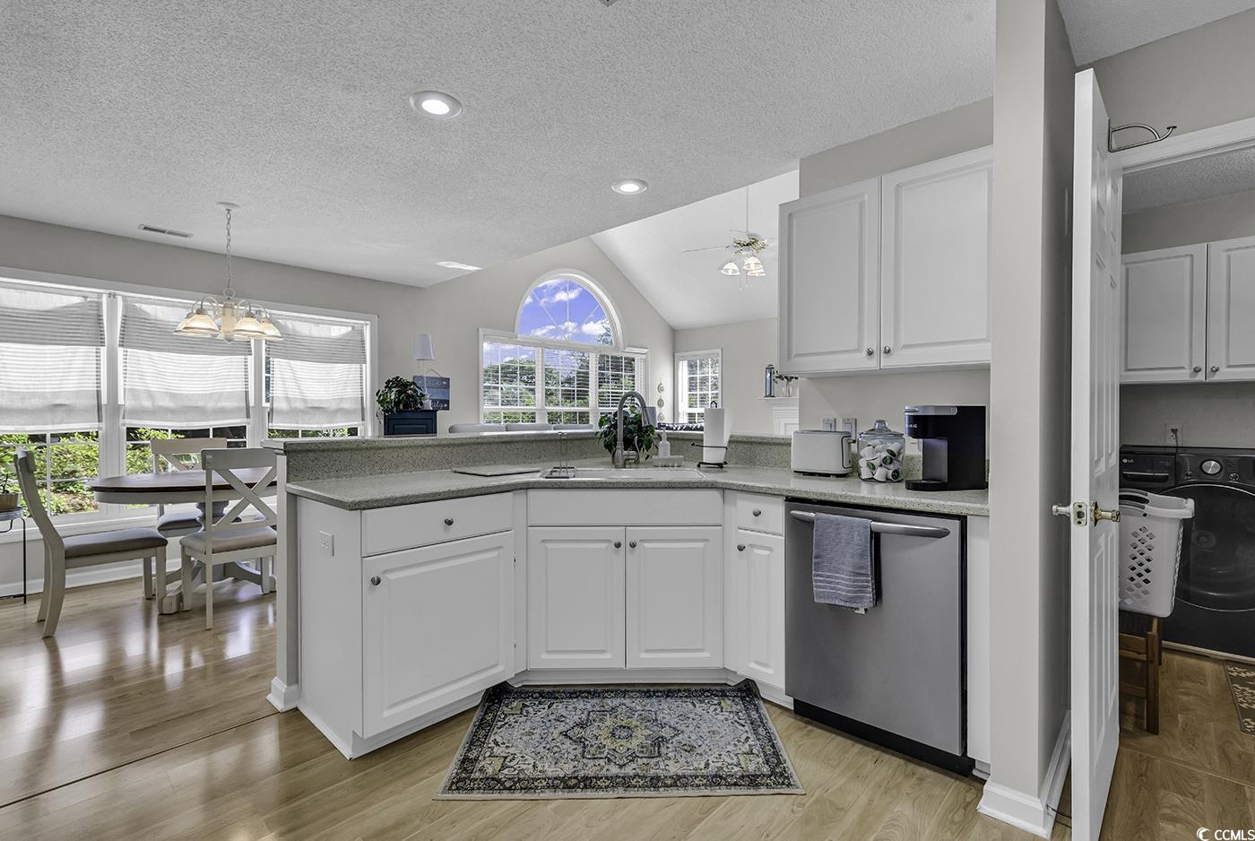 86 Black River Road Myrtle Beach, SC 29588 - Photo 6 of 40 Kitchen with stainless steel dishwasher, a peninsula, white cabinets, and lofted ceiling