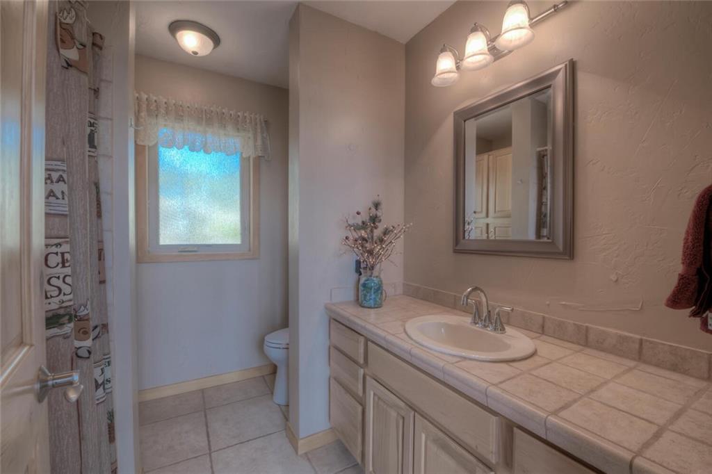 3207 High Creek Road Fairplay, CO 80440 - Photo 18 of 35 a bathroom with a granite countertop sink a toilet and a mirror