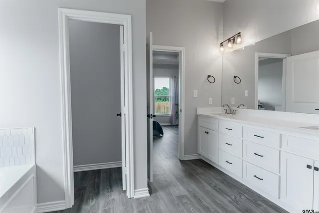 a spacious bathroom with a double vanity sink and a mirror