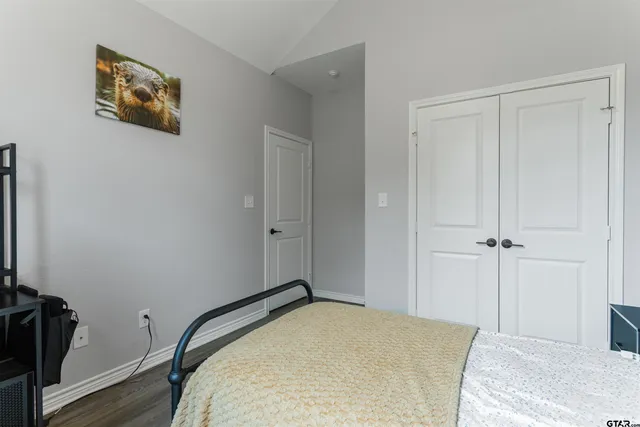 a bedroom with a bed and wooden floor