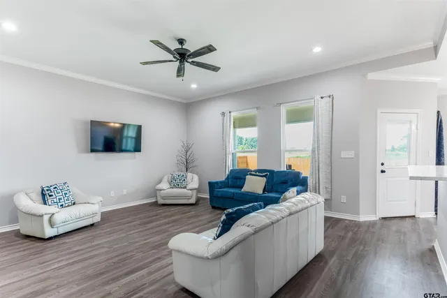 a living room with furniture and a wooden floor