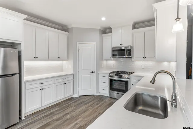 a kitchen with white cabinets and stainless steel appliances