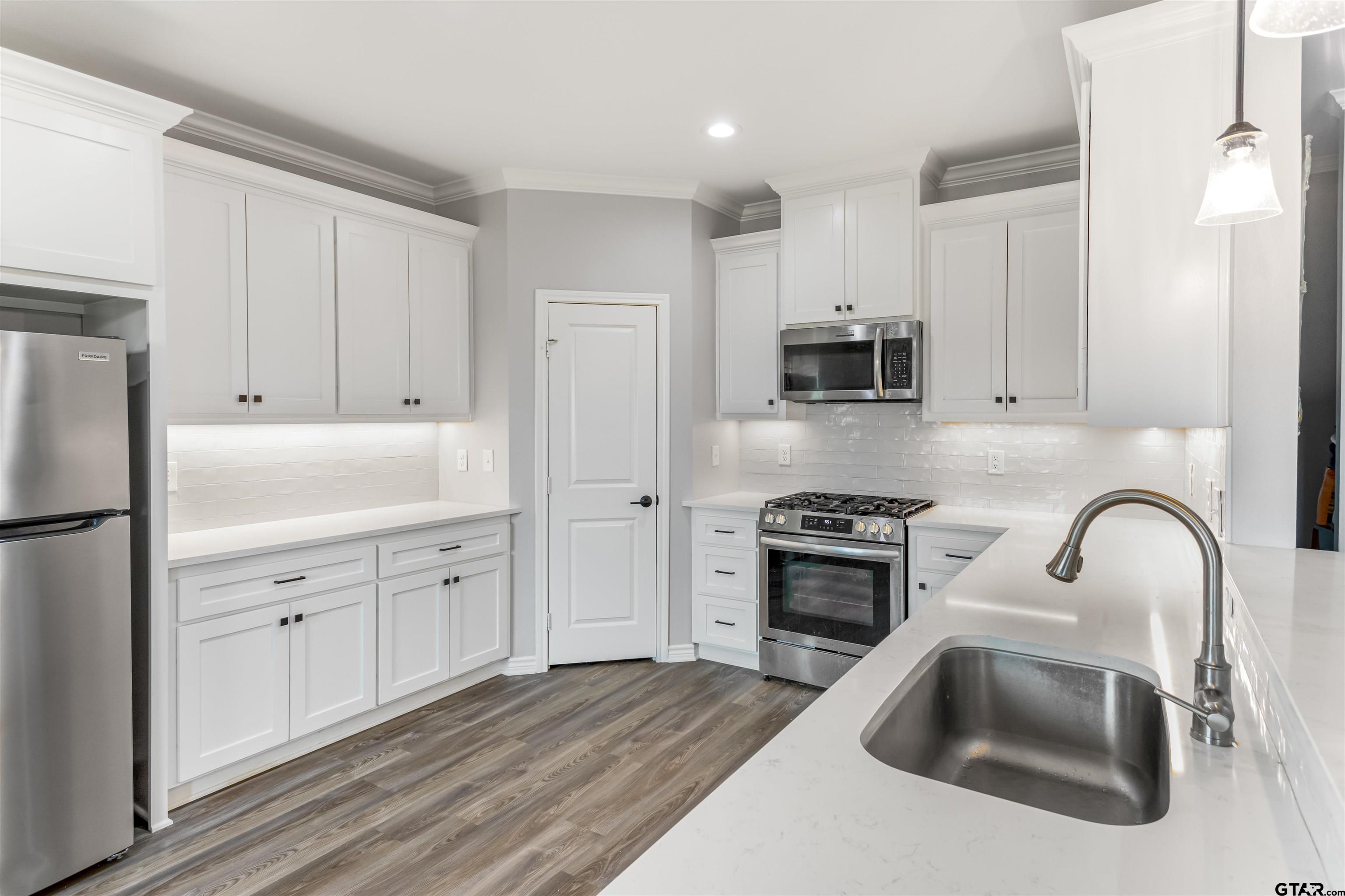 12908 County Road 46 Tyler, TX 75704 - Photo 9 of 20 a kitchen with white cabinets and stainless steel appliances