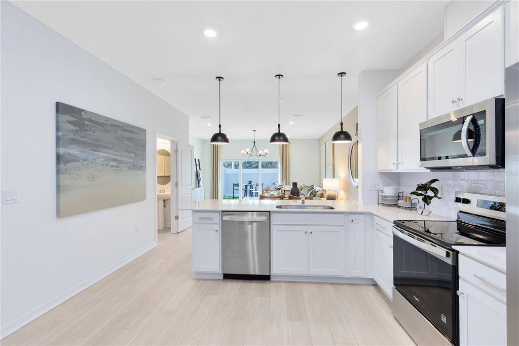 4309 Jetty Lane Palm Bay, FL 32905 - Photo 5 of 28 a kitchen with stainless steel appliances kitchen island granite countertop a stove a sink and a white cabinets