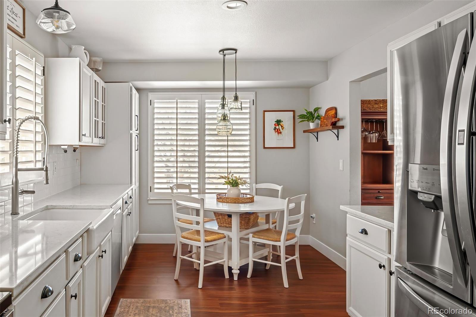 7255 West 97th Place Broomfield, CO 80021 - Photo 24 of 47 a dining room with stainless steel appliances a table chairs and a refrigerator