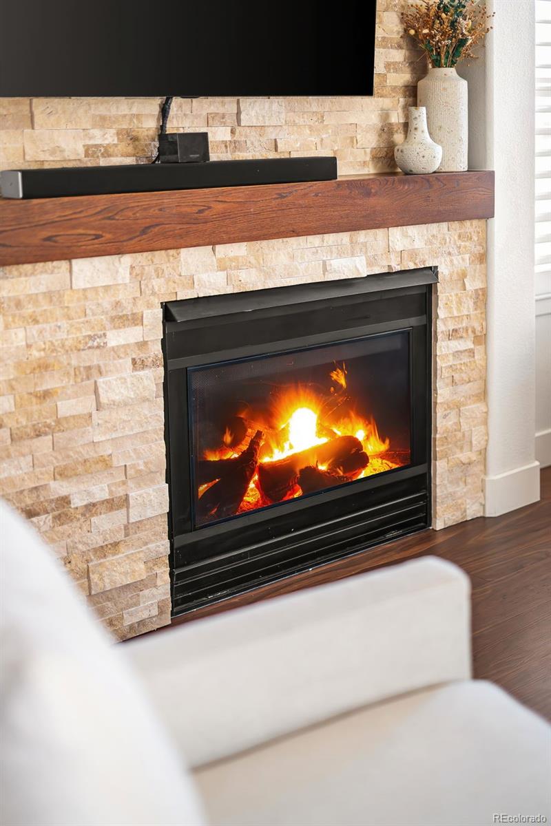 7255 West 97th Place Broomfield, CO 80021 - Photo 10 of 47 a living room with a fireplace and a flat screen tv