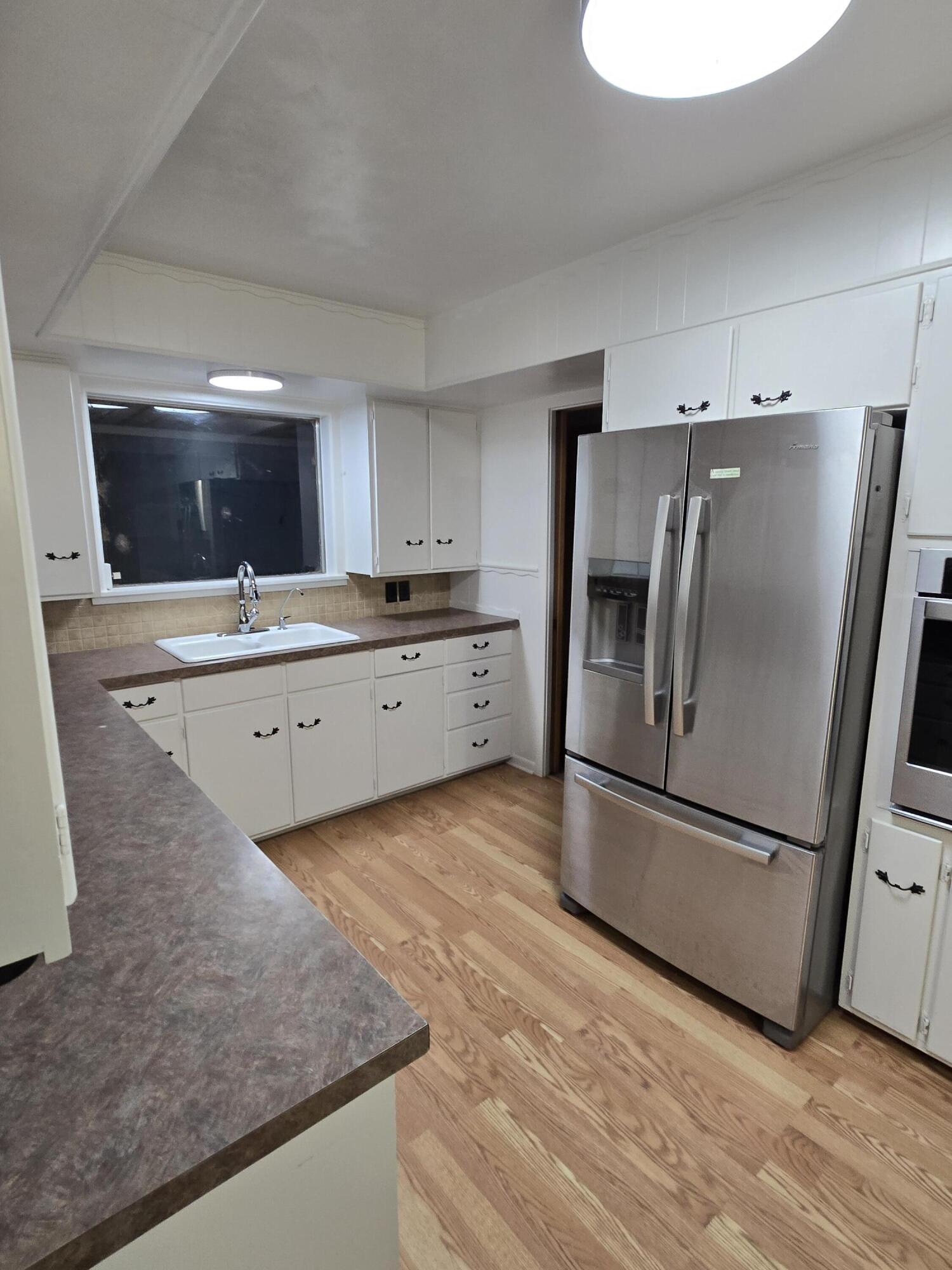 2229 South 6th Street Lamesa, TX 79331 - Photo 4 of 27 a kitchen with granite countertop a refrigerator and a sink
