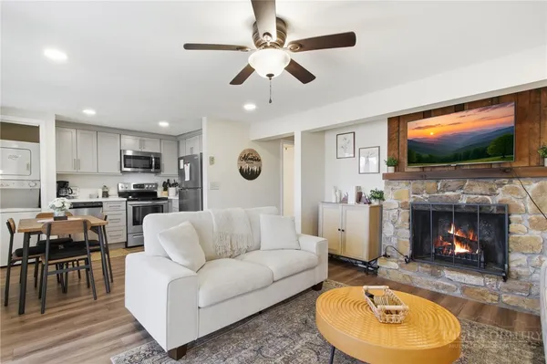 a living room with furniture a fireplace and a flat screen tv