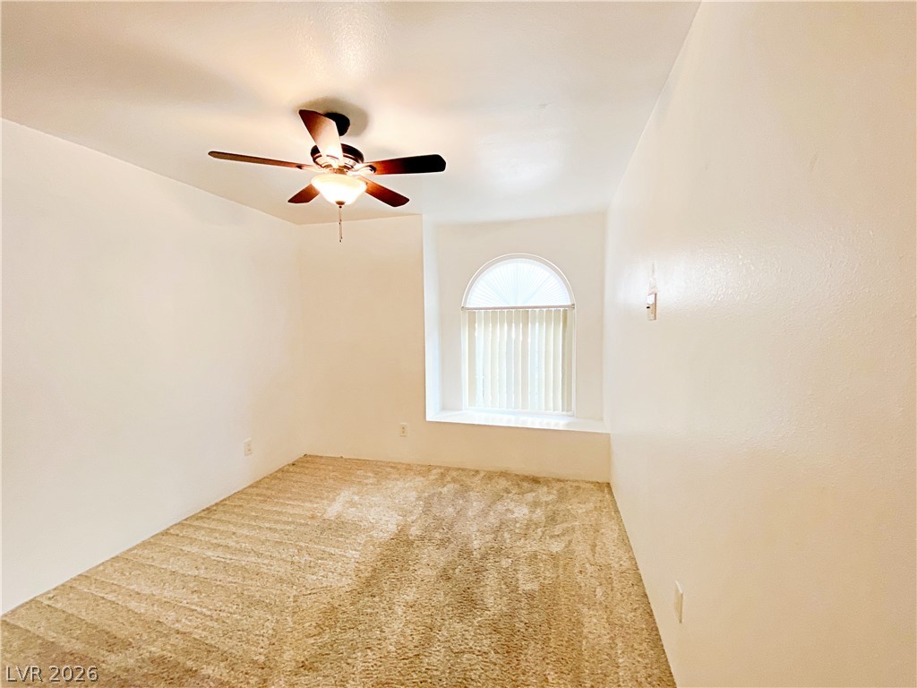 3145 East Flamingo Road, Unit 1128 Las Vegas, NV 89121 - Photo 11 of 19 An airy bedroom offers plush carpeting, a unique arched window, and a ceiling fan for comfort.