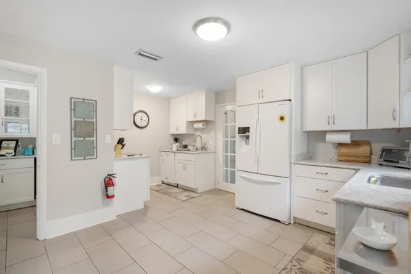a kitchen with white cabinets and white appliances