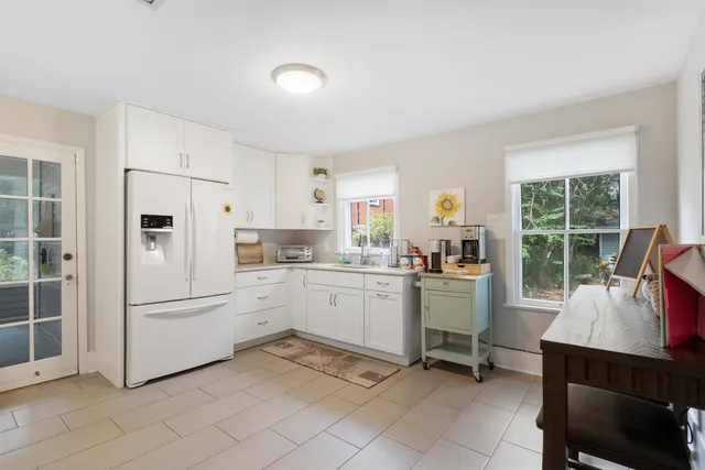 a kitchen with white cabinets and white appliances